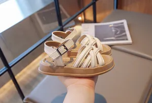 Détail de sandales romaines à brides croisées crème pour filles avec semelle souple