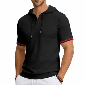 Détail d'un t-shirt à capuche noir pour homme avec poignets contrastés à carreaux