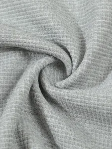 Detailed macro view of grey waffle knit fabric texture showing breathable 3D grid patterns