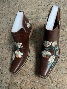 Vista detallada de los botines occidentales marrones para mujer con bordado floral