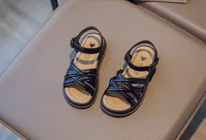 Détail des sandales romaines noires pour filles avec brides croisées et semelle souple