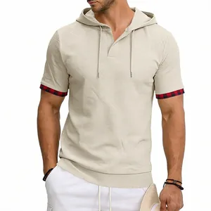 Détail du t-shirt à capuche beige texturé avec des accents de poignets à carreaux