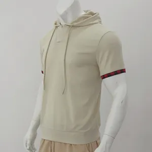 Détail d'un t-shirt à capuche beige pour homme en maille gaufrée avec poignets à carreaux