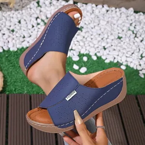 Detailed view of navy blue women wedge sandals featuring intricate laser-cut floral patterns
