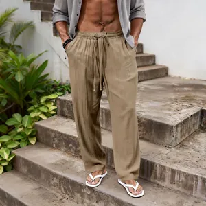 Detail shot of men's loose khaki linen trousers with drawstring waist on stone steps.