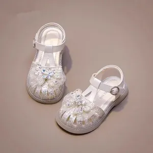 Elegant white glitter girl's princess sandals featuring a rhinestone butterfly bow