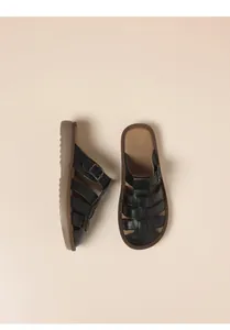 Detailed view of vintage black flat sandals with adjustable buckle strap for women