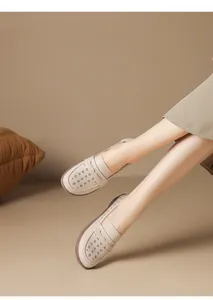 Detailed view of beige perforated leather loafers featuring a comfortable soft sole design.