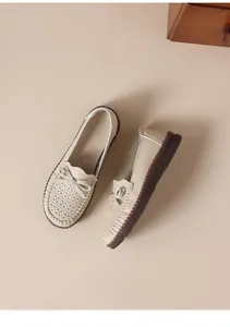 Detailansicht der beigen Leder-Slipper mit Lochmuster und weichen, handgenähten Gummisohlen.