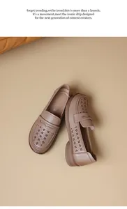 Detail view of stylish beige laser-cut leather loafers for women in a studio setting