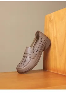 Detail view of soft leather loafer with laser-cut hollow patterns and comfortable flat sole.