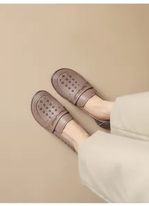 Top view of hollow-out soft leather loafers worn with cream trousers