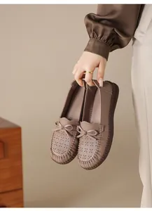 Nahaufnahme von handgenähten Loafers aus weichem Leder mit Lochmuster und Schleife
