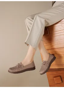 Elegante Detailansicht brauner Leder-Slipper mit handgefertigten Nähten und weicher Sohle.