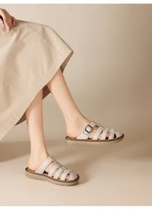 Detailed macro view of beige woven strap slide sandals with soft flat soles on model