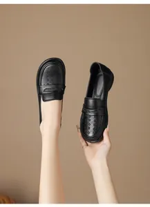 Detailed macro view of black hollowed leather loafers with soft flat soles for women.