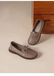 Detailansicht der bequemen braunen Leder-Slipper mit Lochmuster und Schleifendetail