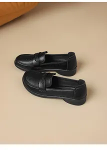 Close-up view of women's black soft leather loafers featuring intricate hollow-out floral patterns