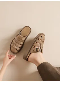 Close-up of retro brown woven leather sandals with adjustable metal buckle strap