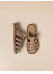 Detailed view of women's tan woven flat sandals with adjustable buckle strap