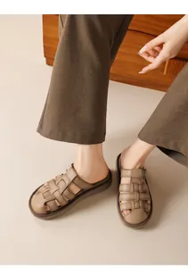 Close-up view of retro brown woven leather-like flat sandals for women shown on feet.