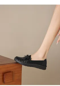 Makrodetail schwarzer weicher Leder-Loafer für Damen mit handgefertigten Nähten und Schleife