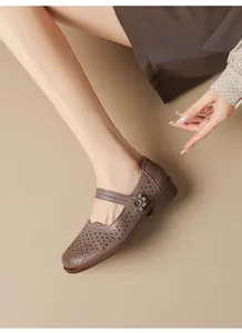 Detailed view of vintage brown laser-cut Mary Jane shoes featuring a flower accent on model