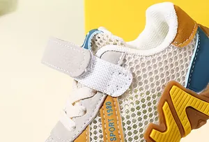 Gros plan sur le mesh blanc respirant et les détails en cuir jaune des baskets enfant