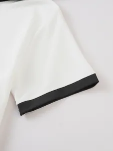 Close-up detail of white waffle knit texture and black ribbed sleeve cuff on polo shirt