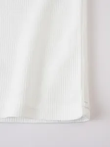 Detailed macro shot of premium white waffle-knit fabric texture on a casual t-shirt