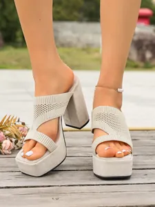 Primo piano di sabot beige in maglia con tacco largo e plateau che mostra la trama del tessuto