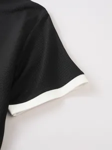 Detailed macro view of black waffle knit fabric texture and white contrast sleeve cuff design