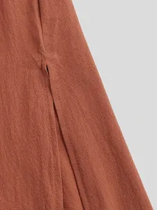 Detailed close-up of the side slit and rust-colored textured fabric on a men's robe