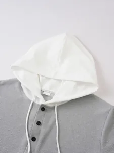 Close-up detail of men's grey waffle knit hooded T-shirt with white drawstring and buttons