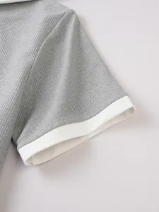 Close-up of gray waffle-knit fabric and white sleeve cuff on casual men's top.