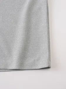 Close-up detail of grey waffle knit fabric texture on a casual men's summer t-shirt