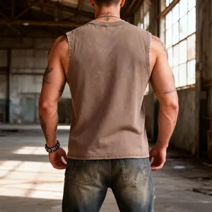 Back view of a men's vintage washed brown cotton tank top in an industrial setting