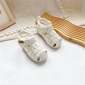 Detailed view of white woven closed-toe sandals for toddlers with adjustable velcro strap