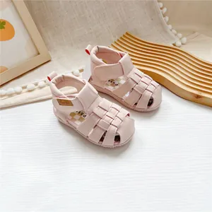 Close-up of pink leather baby sandals with woven straps and secure velcro closure