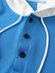Close-up detail of men's waffle knit hooded shirt with button placket and drawstring