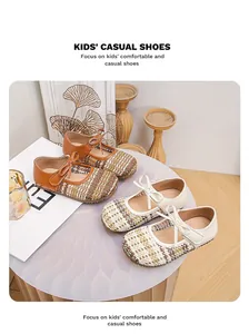 Dettaglio delle scarpe Mary Jane intrecciate retrò da bambina in marrone e beige