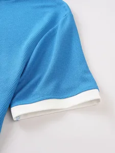Macro close-up view of blue waffle texture short sleeve with white contrast cuff detail