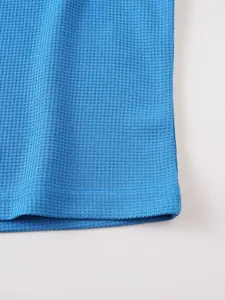 Close-up view of the blue waffle knit fabric and hem stitching on men's casual T-shirt