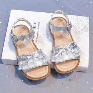 Girls silver princess sandals with lace bow and soft sole for summer beach fun.