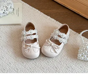 Detailed shot of cream girl's princess shoes featuring daisy lace straps and bow