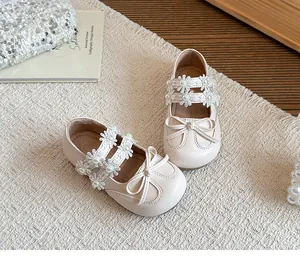 Elegant cream girls princess shoes featuring floral lace straps with pearls and a bow