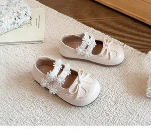 Close-up view of elegant cream girls' princess shoes with lace flower and bow accents