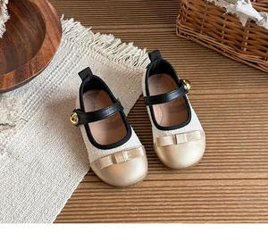 Top-down detail of girls' off-white and gold Mary Jane princess shoes with bow
