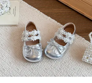 Detail view of silver girls princess shoes featuring elegant pearl flower lace straps and bow