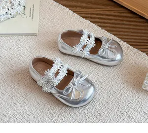 Detail view of silver girl's princess shoes with flower straps and bow accents.